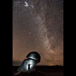 Silhouette of the photographer against the 'Punchbowl' St Agnes, with the Milky way above